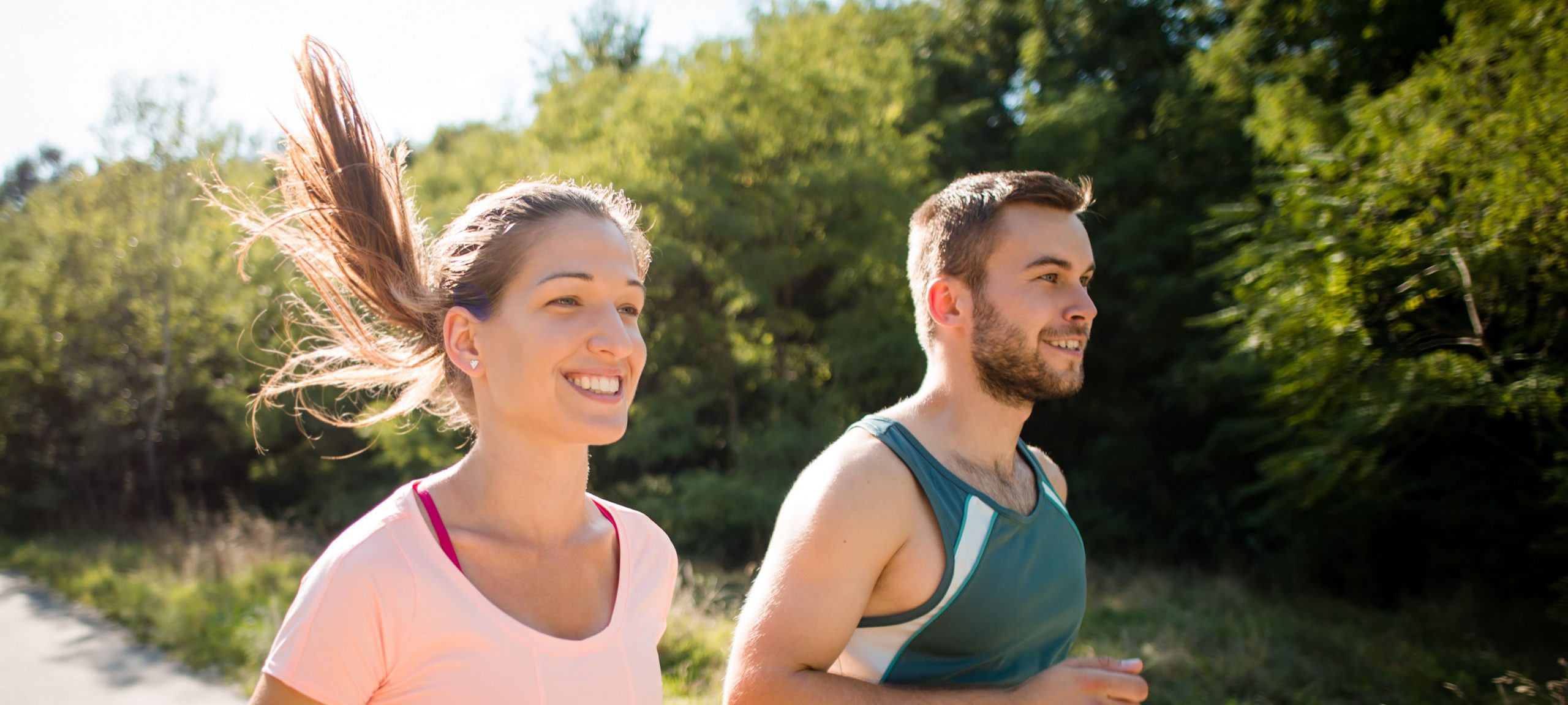 Closeup of smiling friends running together in summer sunny nature