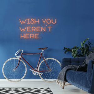 illuminated LED neon sign reading "Wish you weren't here" shown mocked up on wall with clear acrylic backing frame
